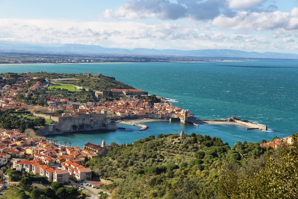 Plage Collioure avec vue sur les eaux turquoise et les façades colorées du village