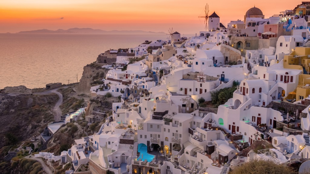 Vue sur Oia à Santorin au coucher du soleil en Grece en mars avec maisons blanches, église et moulin à vent