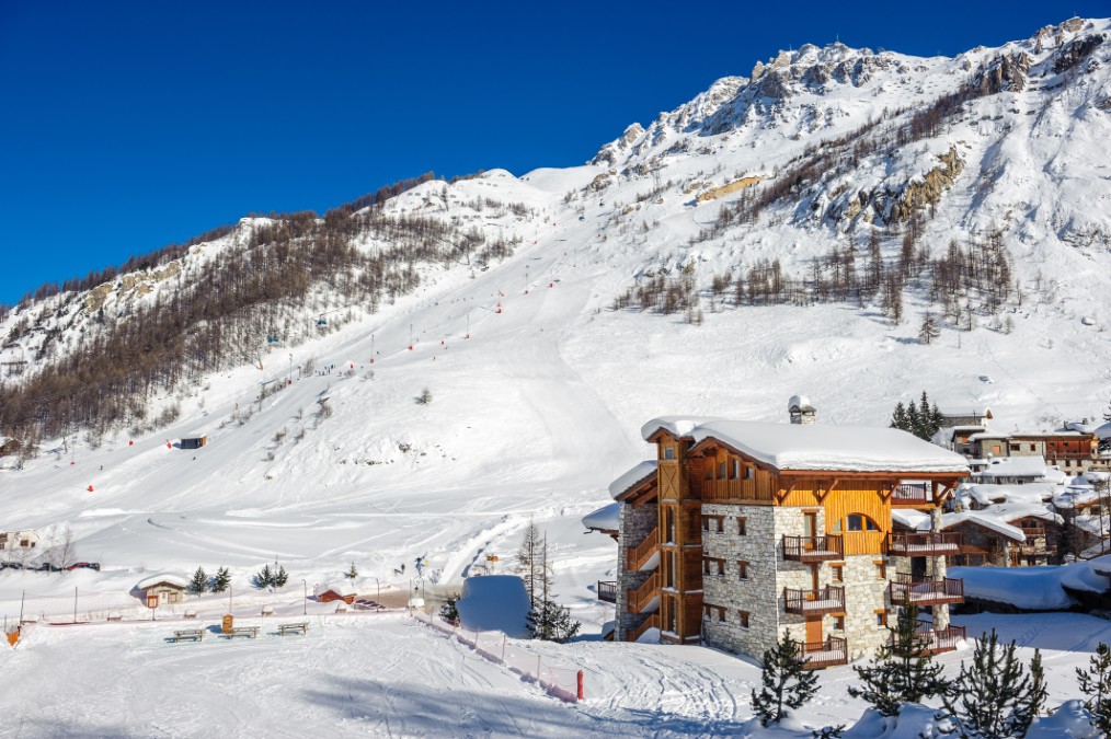 Une grande résidence de tourisme en pierre et bois située au pied des pistes de ski.