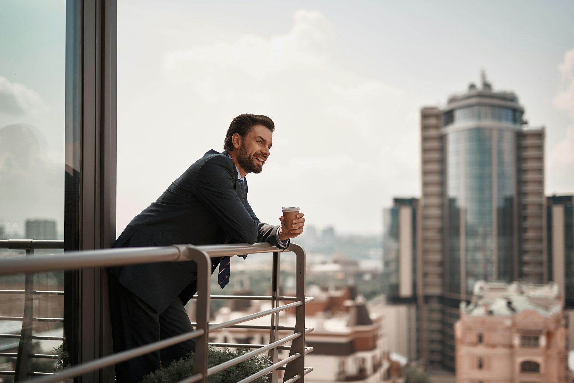 Comment trouver le meilleur quartier pour votre logement ? Un habitant satisfait profite de la vue sur la ville depuis son balcon.